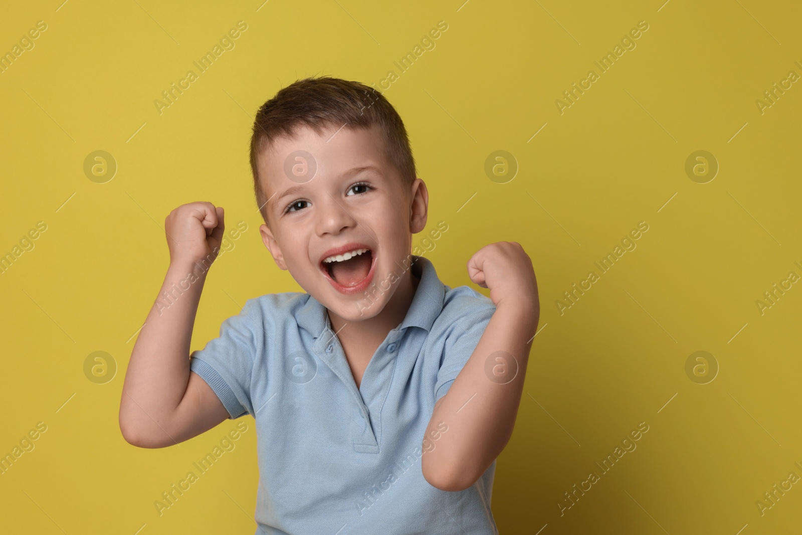 Photo of Portrait of cute little boy on yellow background