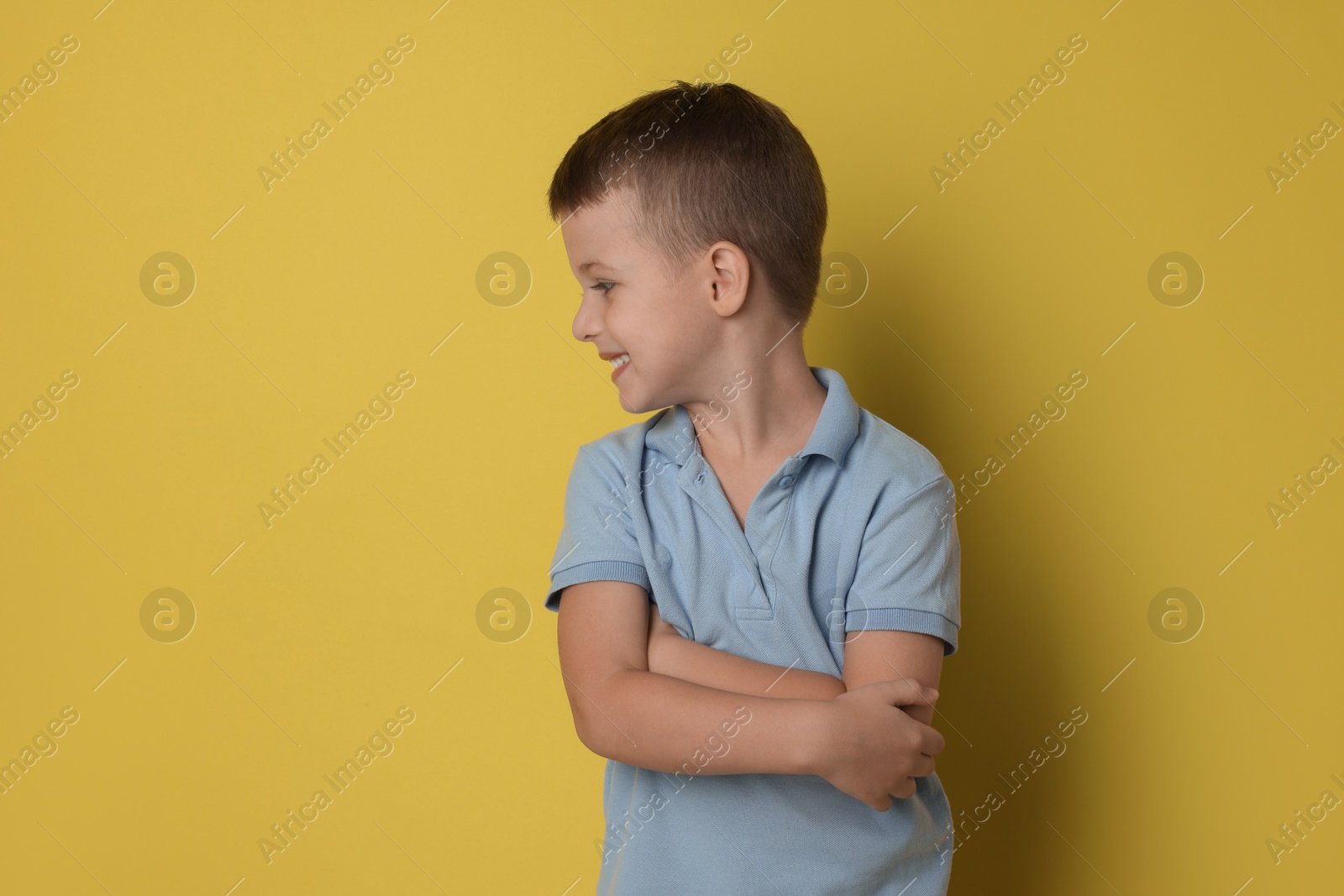 Photo of Portrait of cute little boy on yellow background, space for text