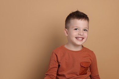 Photo of Portrait of cute little boy on pale background, space for text