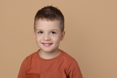 Portrait of cute little boy on pale background