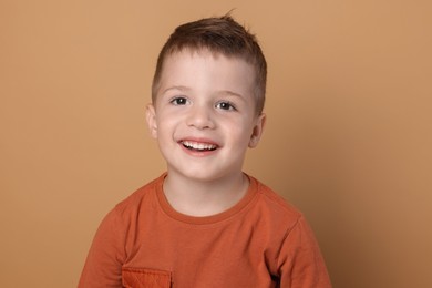 Portrait of cute little boy on pale background