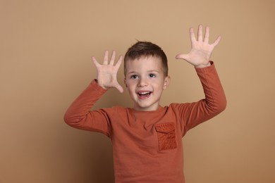 Portrait of cute little boy on pale background