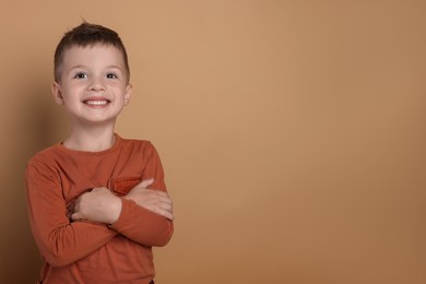 Photo of Portrait of cute little boy on pale background, space for text