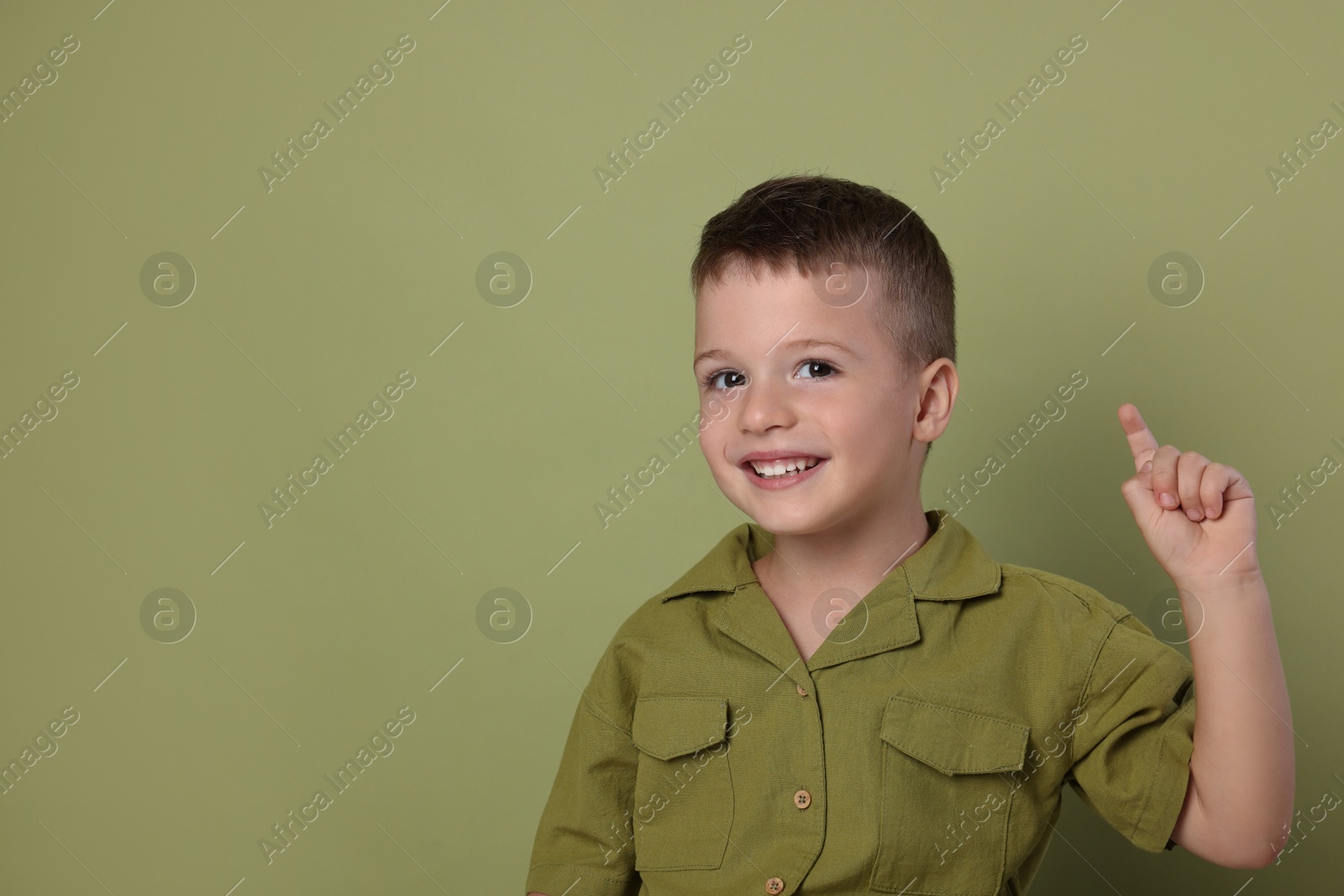 Photo of Portrait of cute little boy on green background, space for text