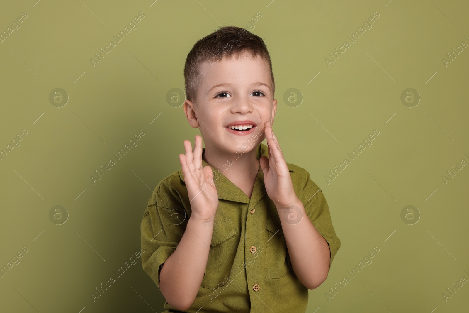 Photo of Portrait of cute little boy on green background