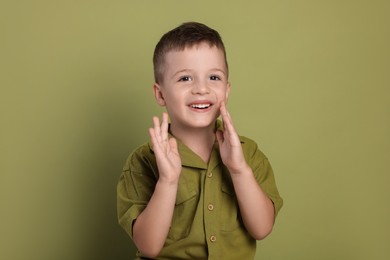 Portrait of cute little boy on green background