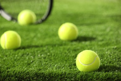 Photo of Tennis balls on green grass, selective focus