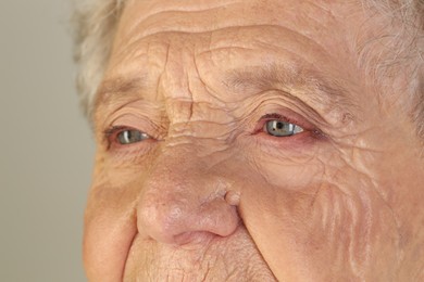 Photo of Senior woman with beautiful eyes on grey background, closeup