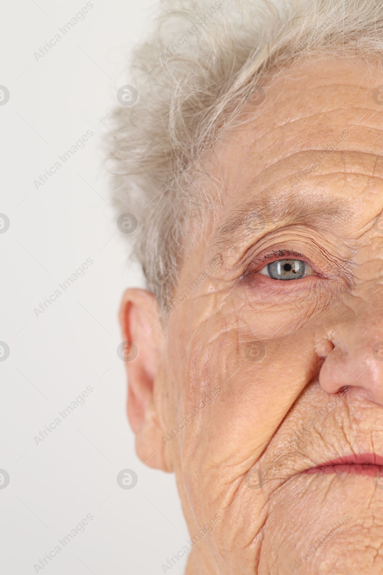 Photo of Senior woman with beautiful eyes on white background, closeup