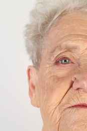 Senior woman with beautiful eyes on white background, closeup