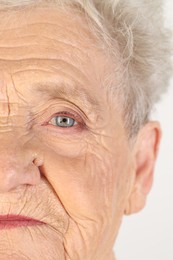 Photo of Senior woman with beautiful eyes on white background, closeup