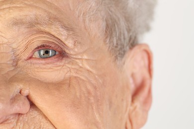 Photo of Senior woman with beautiful eyes on white background, closeup