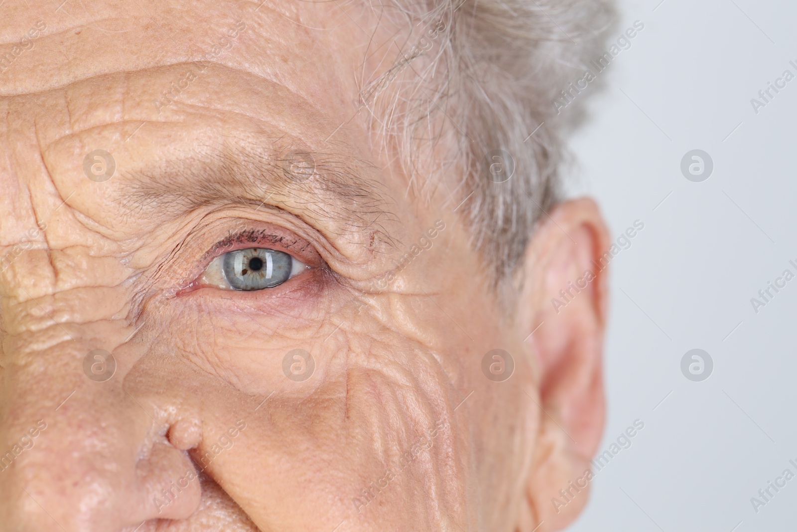 Photo of Senior woman with beautiful eyes on white background, closeup