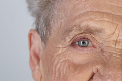 Photo of Senior woman with beautiful eyes on white background, closeup