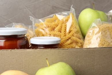 Photo of Different food products for donation in box, closeup