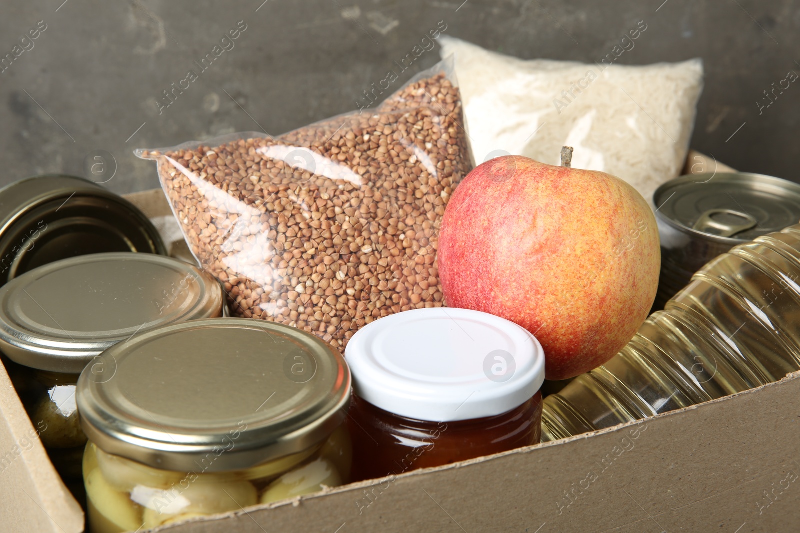 Photo of Different food products for donation in box, closeup