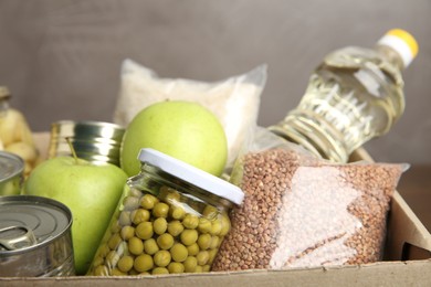 Photo of Different food products for donation in box, closeup