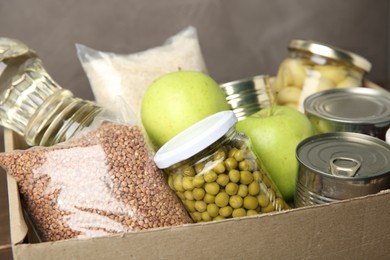 Photo of Different food products for donation in box, closeup