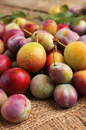 Photo of Pile of tasty ripe plums on table, closeup