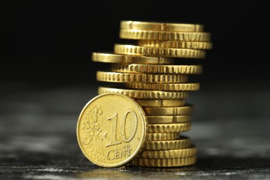 Photo of Stacked euro coins on dark table, closeup