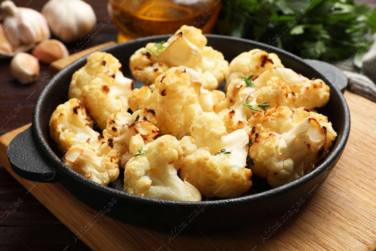 Photo of Tasty baked cauliflower in baking pan on table, closeup