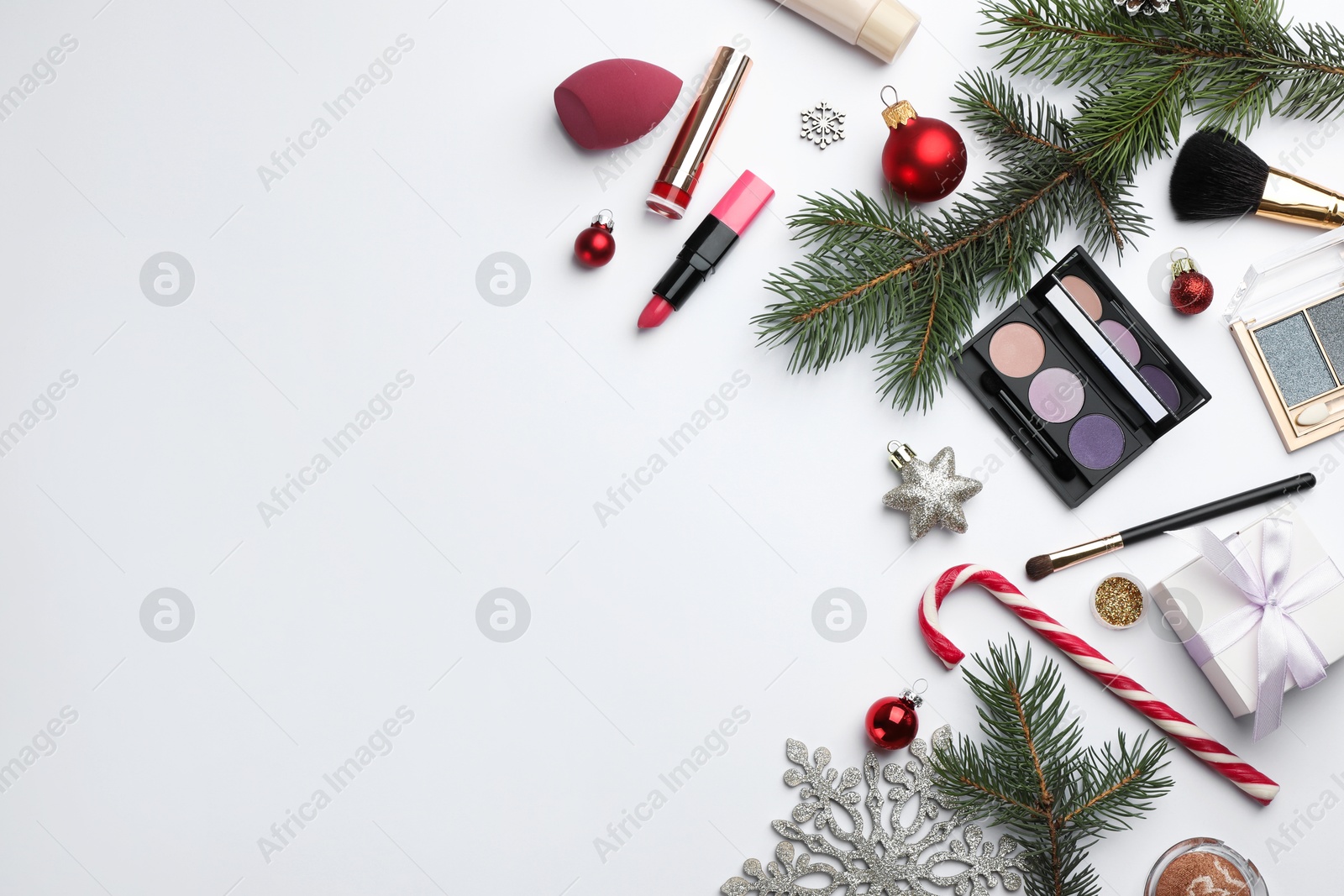 Photo of Different decorative cosmetic products and Christmas decor on white background, flat lay. Space for text