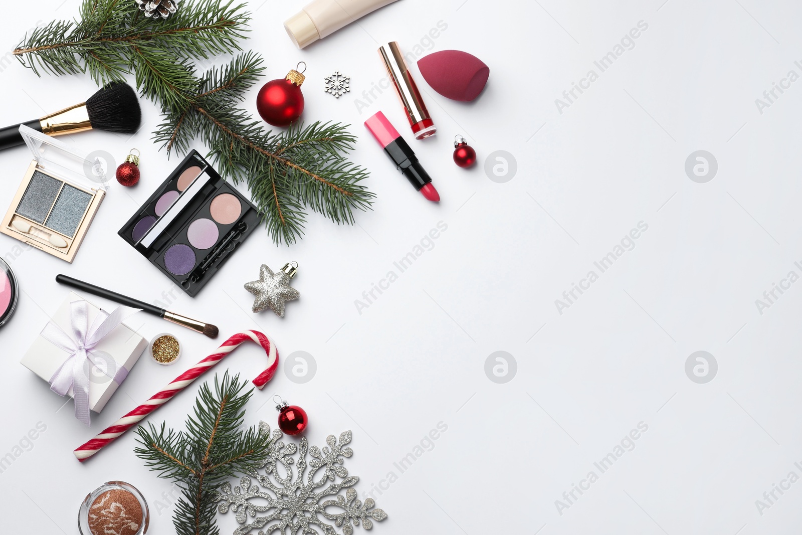 Photo of Different decorative cosmetic products and Christmas decor on white background, flat lay. Space for text