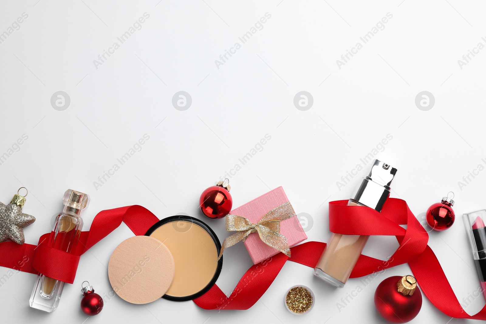 Photo of Different decorative cosmetic products and Christmas decor on white background, flat lay. Space for text