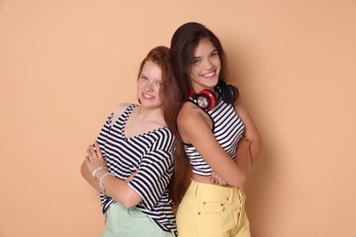 Happy teenage girls posing on beige background