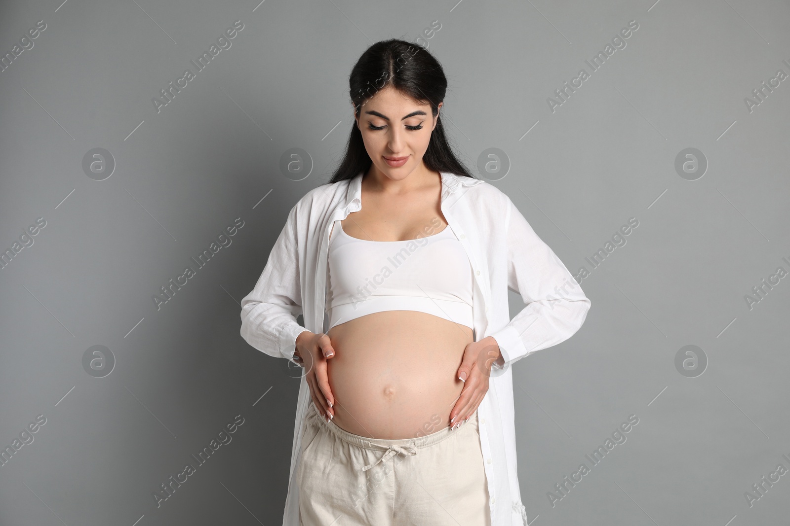 Photo of Portrait of beautiful pregnant woman on grey background