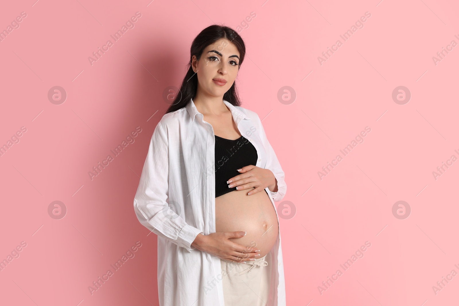 Photo of Portrait of beautiful pregnant woman on pink background