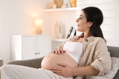 Photo of Young pregnant woman lying on bed at home, space for text