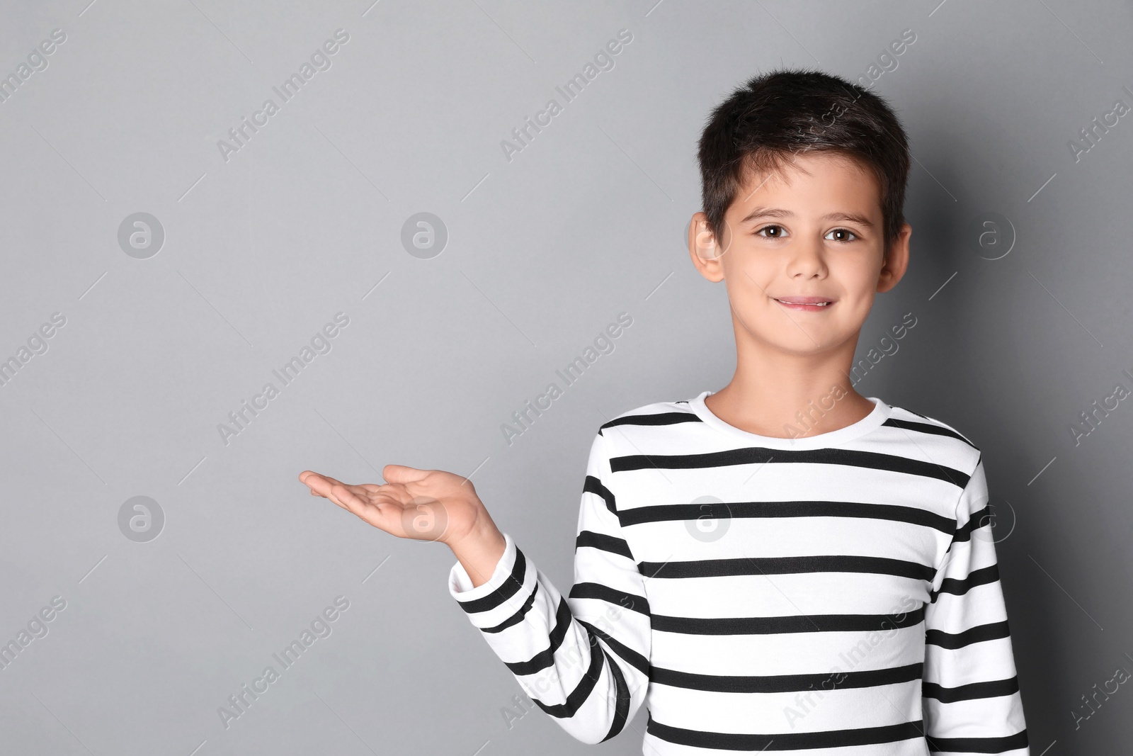 Photo of Portrait of cute little boy on grey background