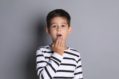 Portrait of cute little boy on grey background