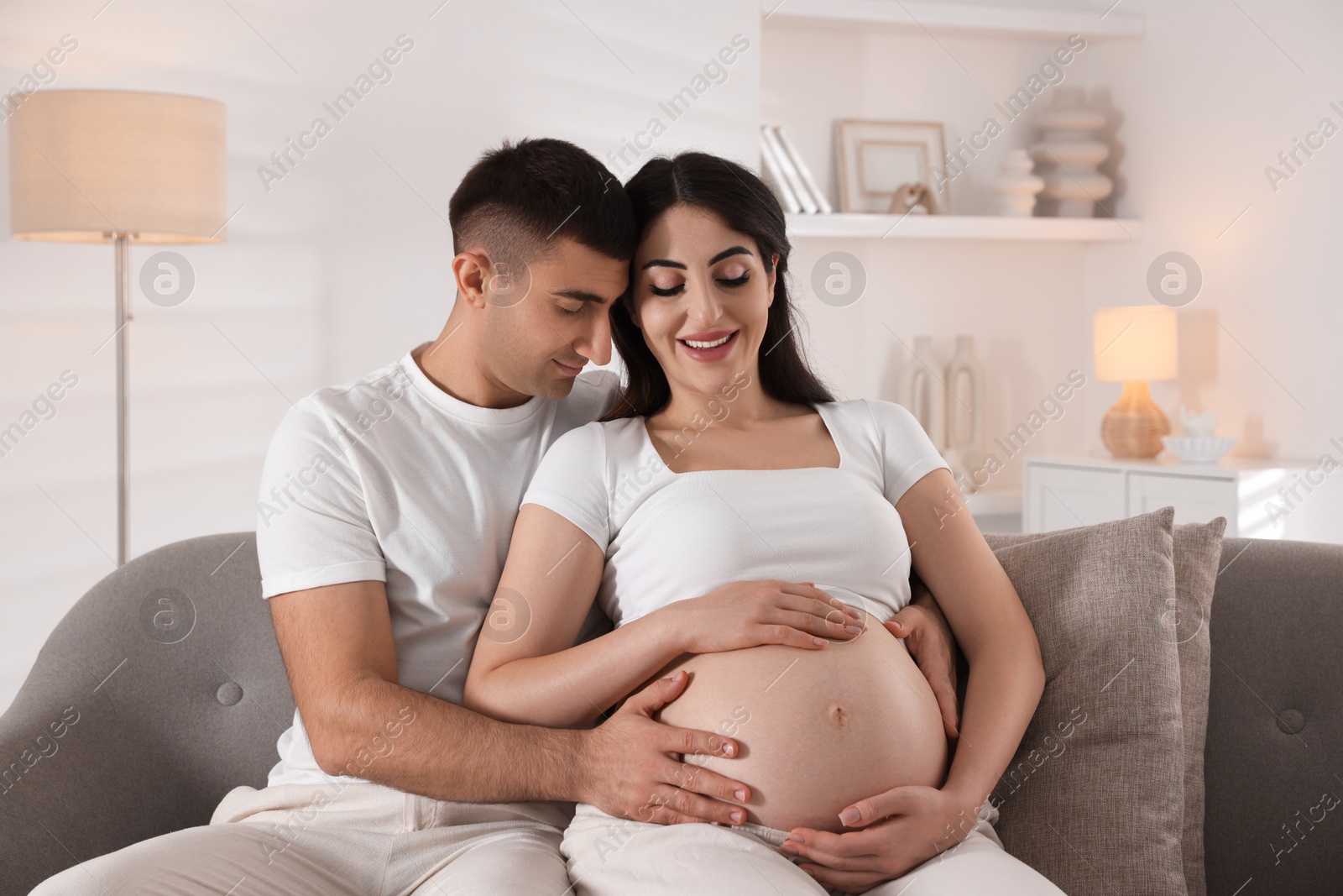 Photo of Beautiful pregnant woman spending time with her husband at home