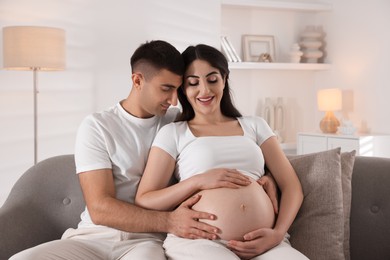 Photo of Beautiful pregnant woman spending time with her husband at home