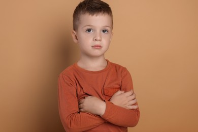 Portrait of cute little boy on pale background