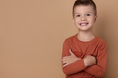 Portrait of cute little boy on pale background, space for text