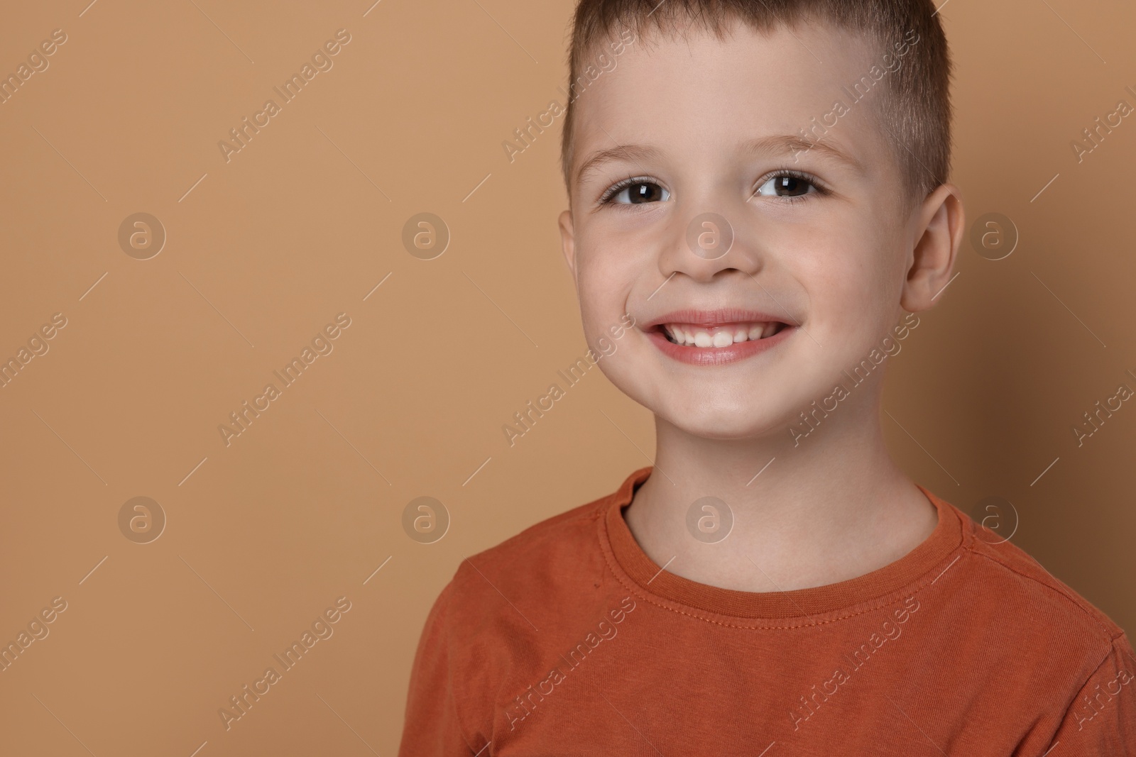 Photo of Portrait of cute little boy on pale background, space for text