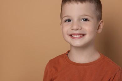 Photo of Portrait of cute little boy on pale background, space for text