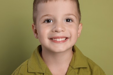 Photo of Portrait of cute little boy on green background