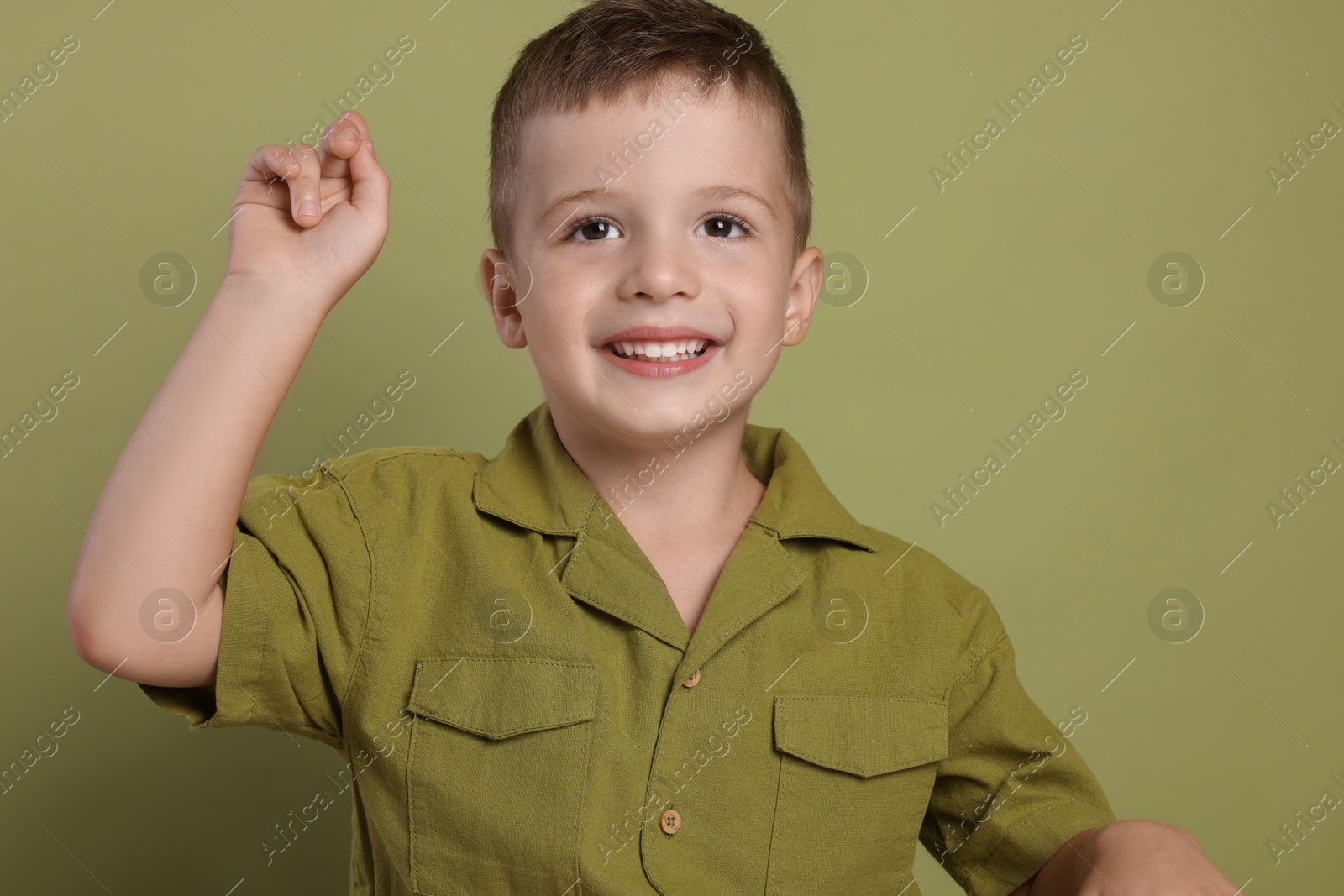 Photo of Portrait of cute little boy on green background