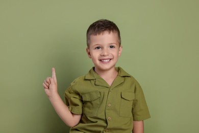 Portrait of cute little boy on green background