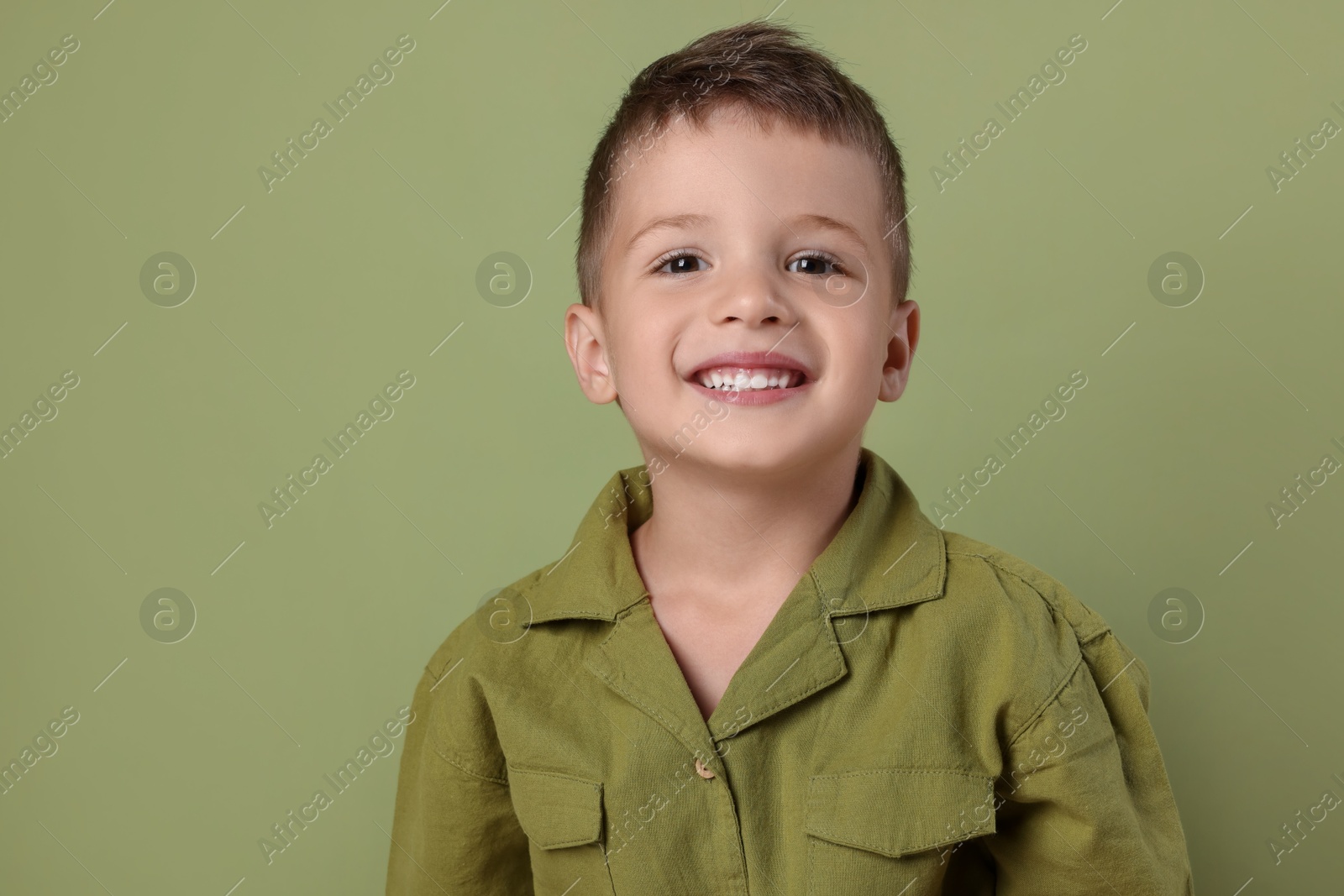 Photo of Portrait of cute little boy on green background