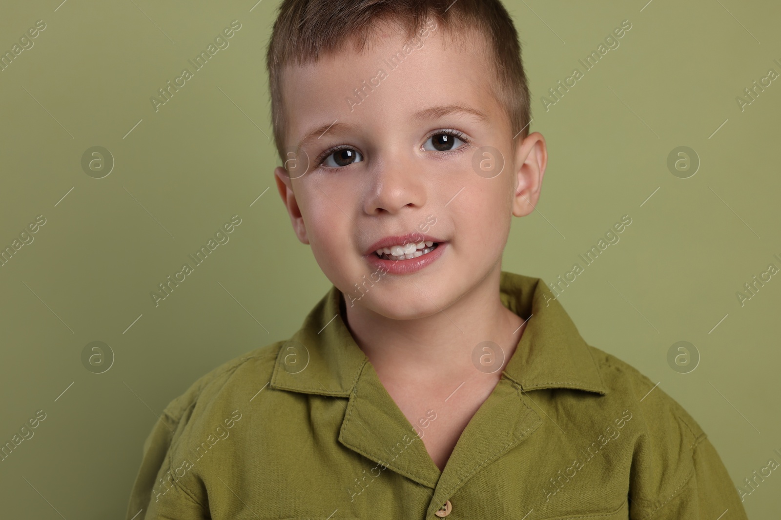 Photo of Portrait of cute little boy on green background