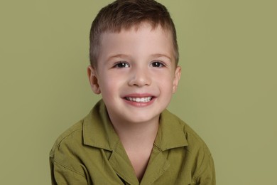 Photo of Portrait of cute little boy on green background