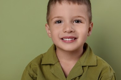 Photo of Portrait of cute little boy on green background