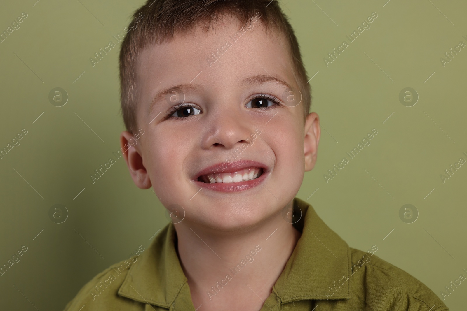 Photo of Portrait of cute little boy on green background