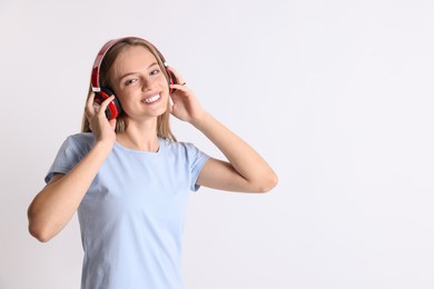 Photo of Teenage girl in headphones on white background, space for text