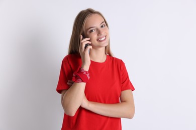 Photo of Teenage girl talking on smartphone against white background